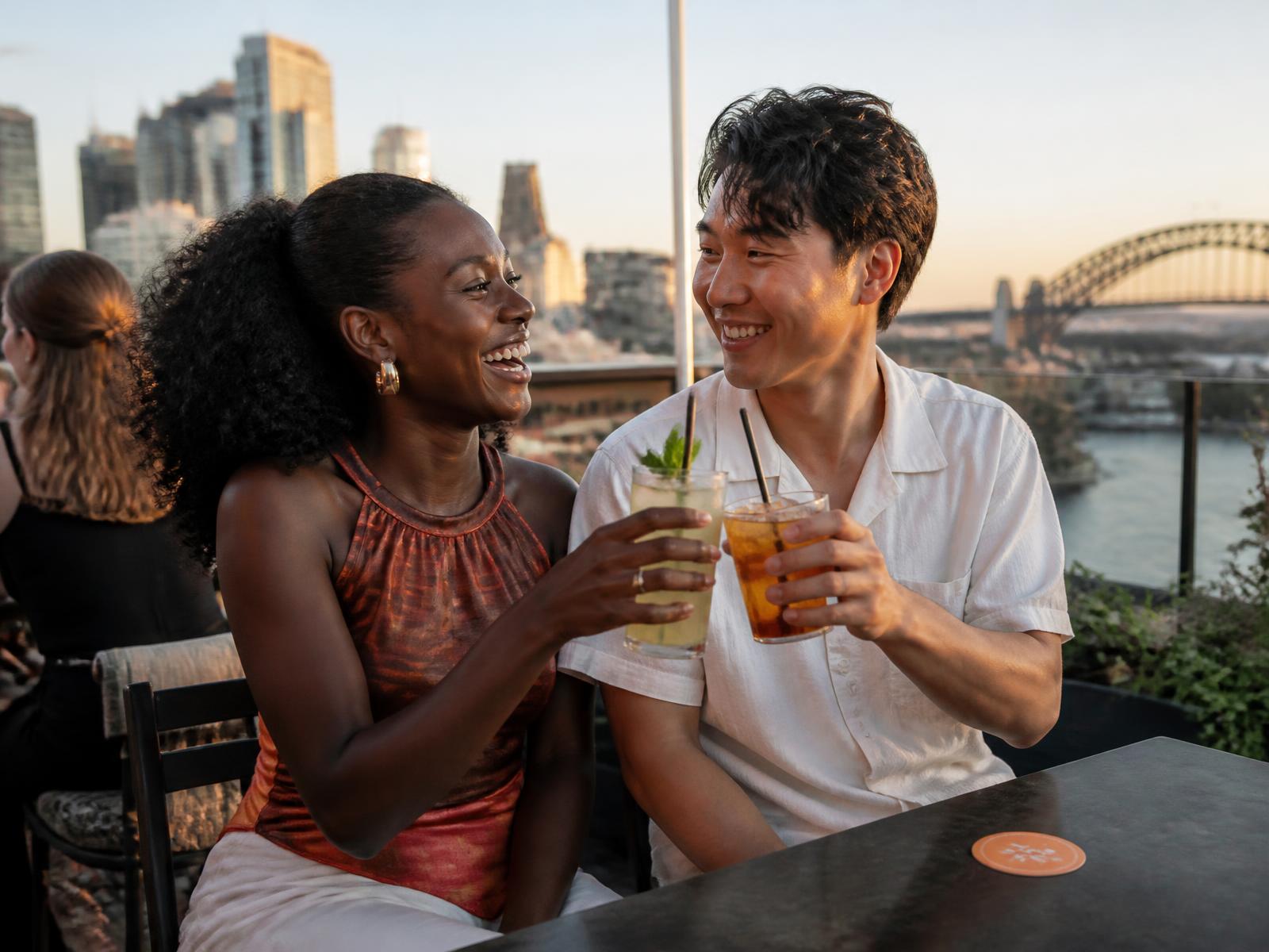 A couple enjoying drinks together at a Sydney rooftop bar